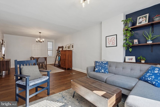 living area featuring a chandelier, baseboards, and wood finished floors