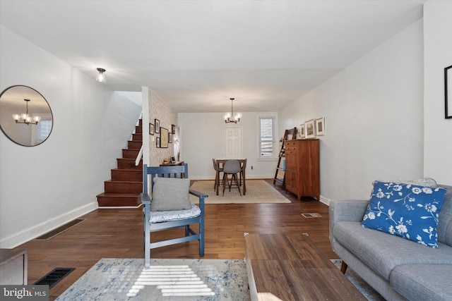 living area featuring visible vents, a notable chandelier, and wood finished floors