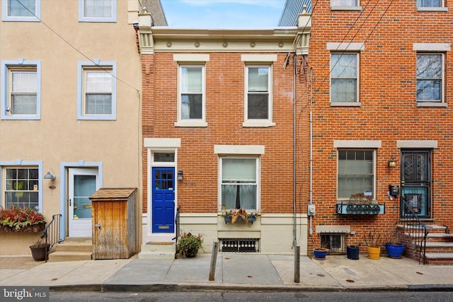 townhome / multi-family property featuring entry steps and brick siding