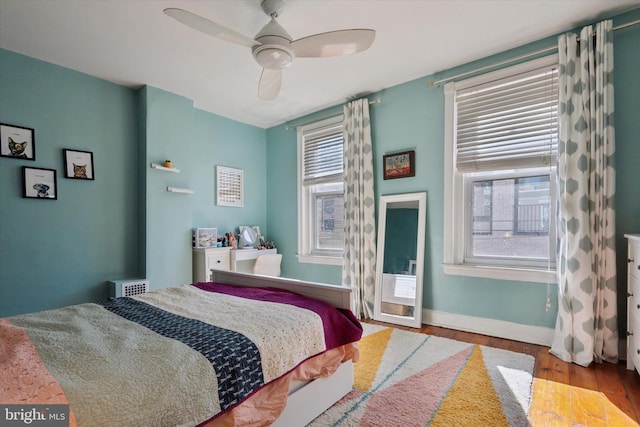 bedroom featuring ceiling fan, baseboards, and wood finished floors