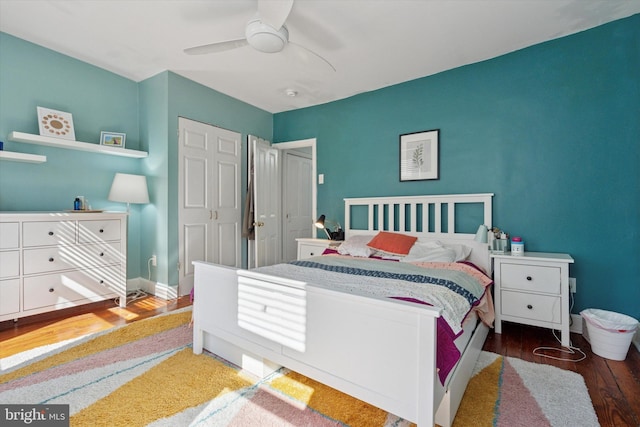 bedroom with ceiling fan, a closet, baseboards, and wood finished floors