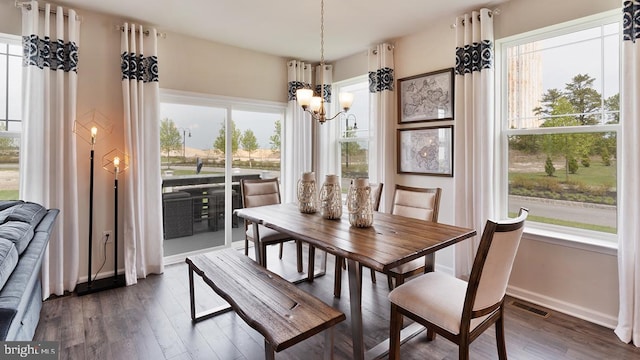 dining space featuring baseboards, a notable chandelier, visible vents, and dark wood-style flooring