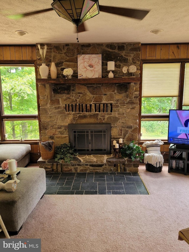 living area with carpet, a fireplace, and a textured ceiling