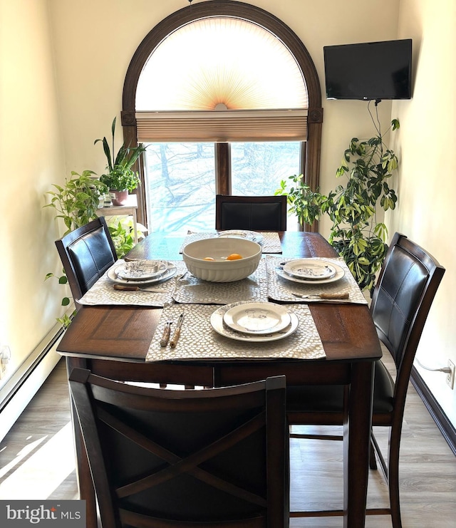 dining area with a baseboard radiator and wood finished floors