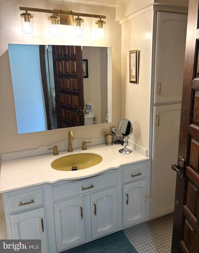 bathroom with toilet, tile patterned flooring, and vanity