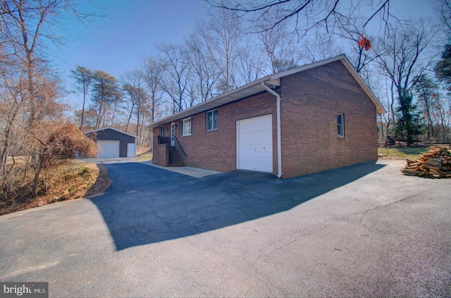 view of side of property featuring an outdoor structure and brick siding