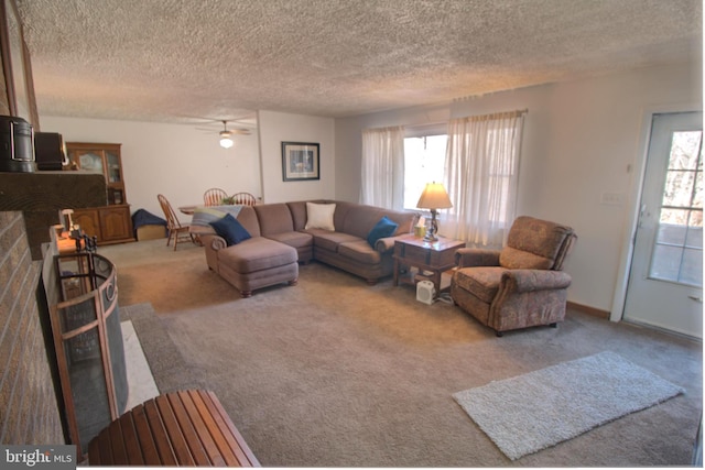 carpeted living room with a textured ceiling, ceiling fan, a wealth of natural light, and baseboards