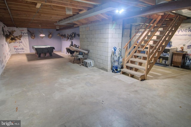 unfinished basement featuring billiards and stairs