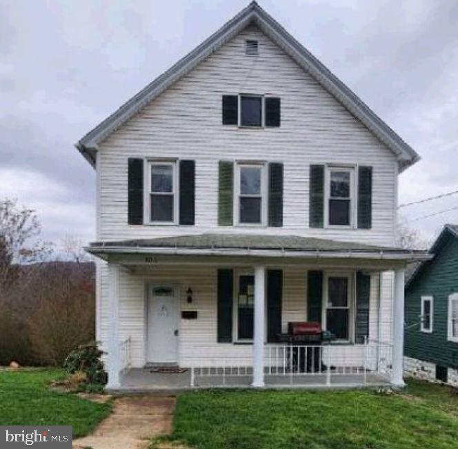 view of front facade with covered porch and a front yard