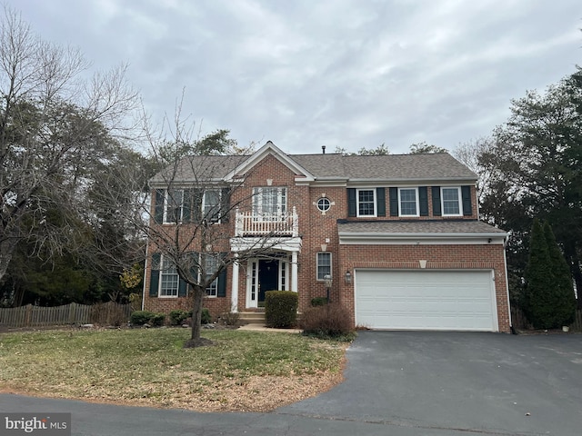 view of front of house with aphalt driveway, brick siding, an attached garage, fence, and a balcony