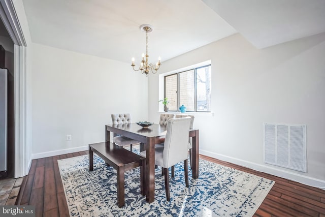 dining room featuring an inviting chandelier, wood finished floors, visible vents, and baseboards