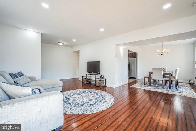 living room featuring recessed lighting, a notable chandelier, and hardwood / wood-style flooring