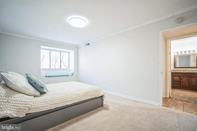 bedroom with baseboards, visible vents, connected bathroom, light colored carpet, and crown molding