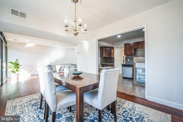 dining space featuring recessed lighting, wood-type flooring, visible vents, a chandelier, and baseboards