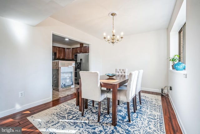 dining space featuring a notable chandelier, wood finished floors, and baseboards