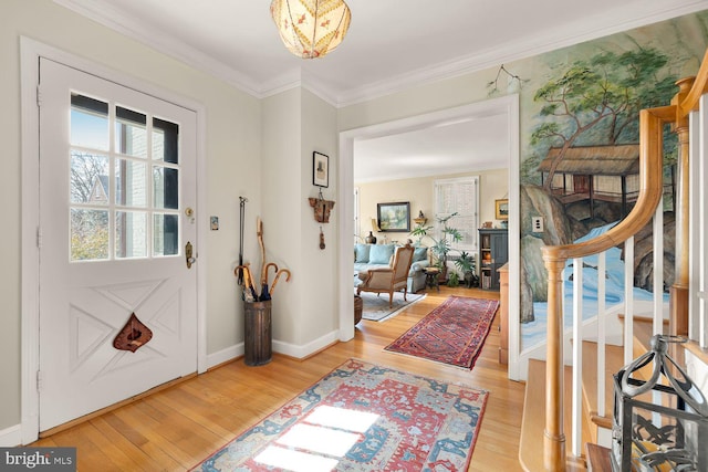 foyer featuring baseboards, stairway, light wood-style flooring, and crown molding