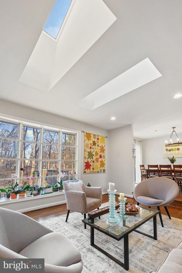 living room featuring recessed lighting, a healthy amount of sunlight, a skylight, and wood finished floors