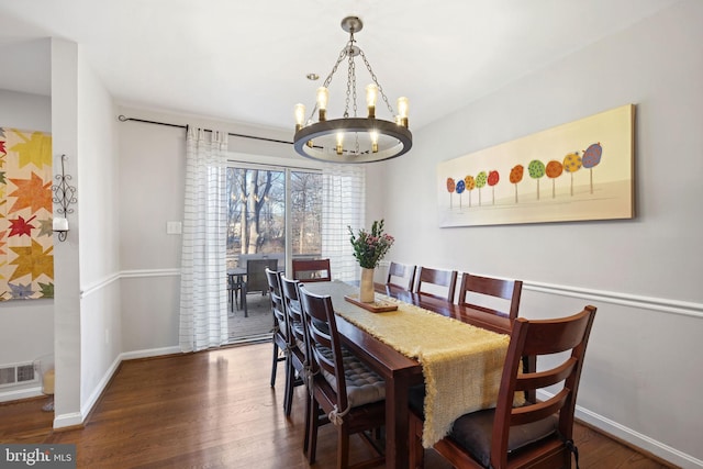 dining room featuring a chandelier, visible vents, baseboards, and wood finished floors