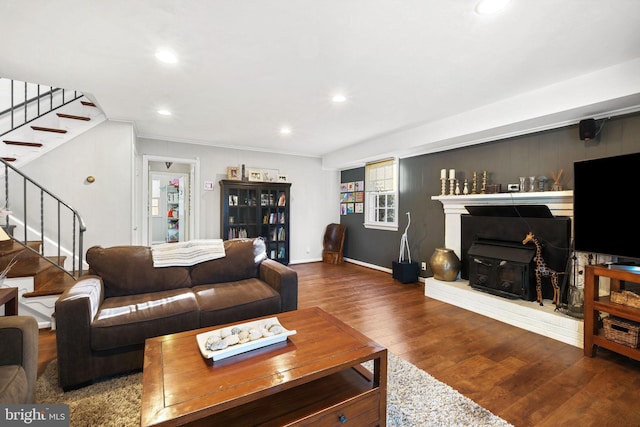 living room with wood finished floors, stairs, recessed lighting, baseboards, and a wood stove