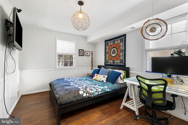 bedroom featuring visible vents, baseboards, and wood finished floors