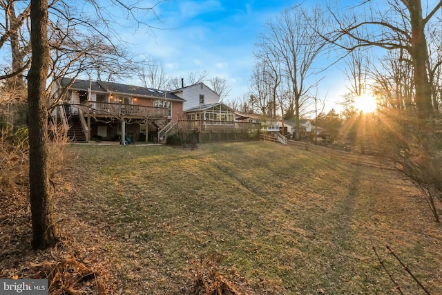 view of yard with a deck, stairway, and fence