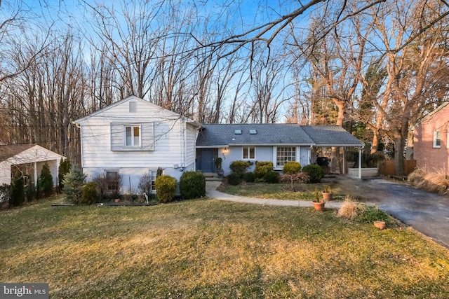 view of front of home with aphalt driveway, a carport, and a front yard