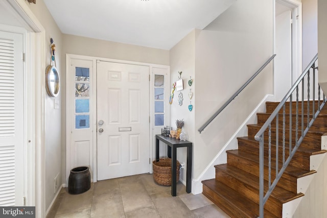 entryway featuring stairs and baseboards