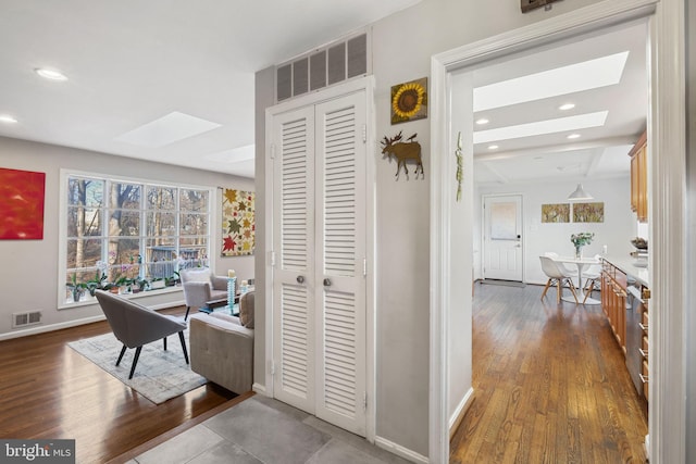 office space featuring recessed lighting, visible vents, a skylight, and dark wood finished floors