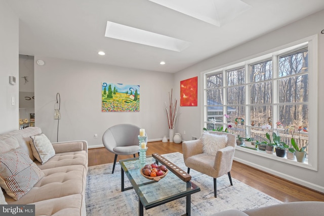 living room with recessed lighting, baseboards, wood finished floors, and a skylight