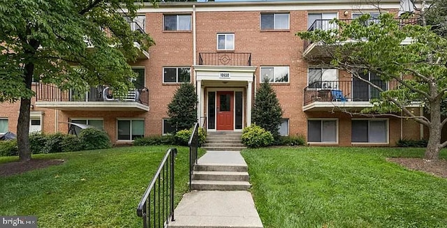 view of front of house with brick siding and a front lawn