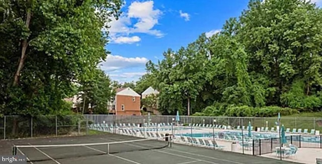 view of sport court with fence and a community pool