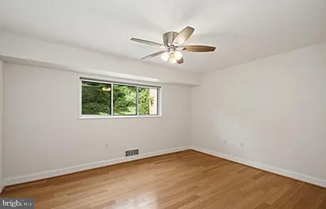 empty room featuring ceiling fan, wood finished floors, and baseboards