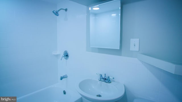 full bathroom featuring washtub / shower combination and a sink