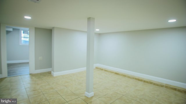 basement featuring recessed lighting, baseboards, and light tile patterned flooring