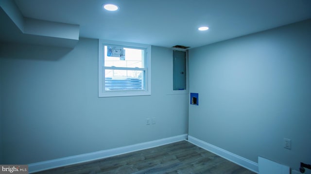 interior space with washer hookup, electric panel, dark wood-style floors, baseboards, and laundry area