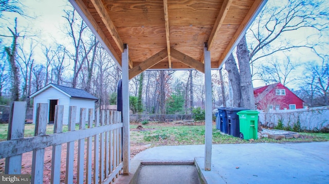 view of patio / terrace with a storage shed, an outdoor structure, and fence