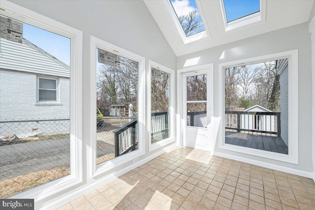 unfurnished sunroom with vaulted ceiling with skylight