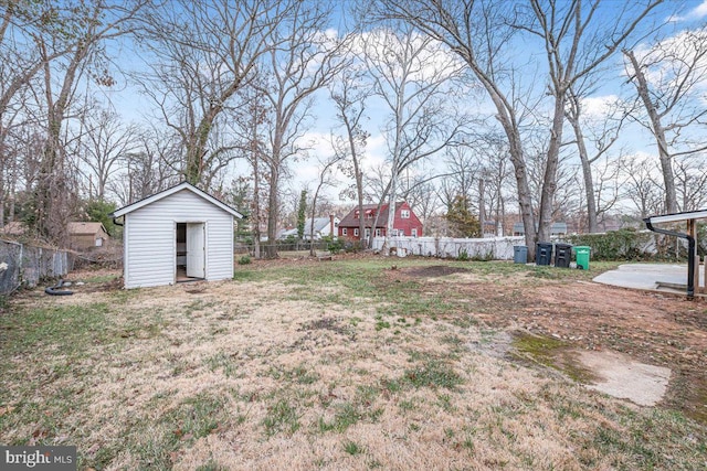 view of yard with a storage shed, an outbuilding, and a fenced backyard