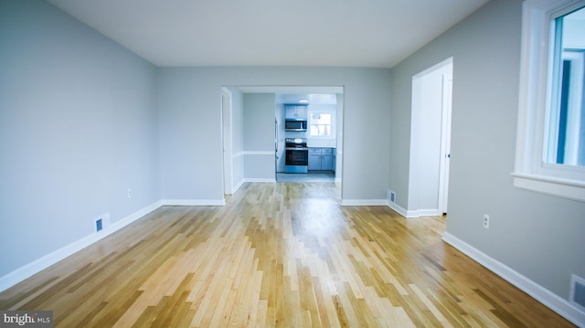 unfurnished room with visible vents, baseboards, and light wood-style floors