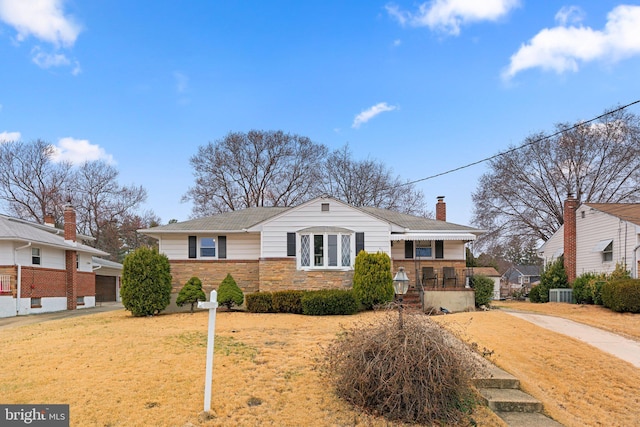 view of front of house with a front yard, central AC unit, a chimney, an outdoor structure, and stone siding