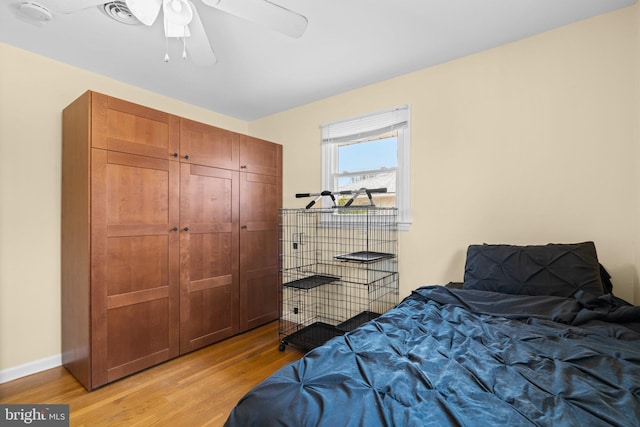 bedroom with a ceiling fan, baseboards, and light wood finished floors