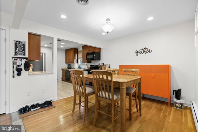 dining room with light wood-style flooring, recessed lighting, and baseboard heating