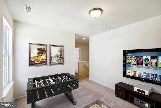 rec room featuring baseboards, visible vents, and light colored carpet