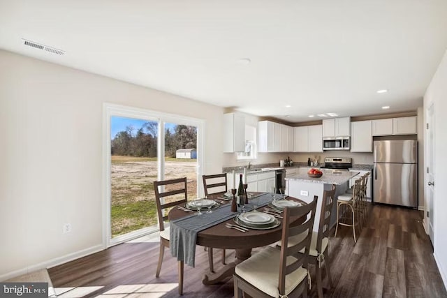 dining area with baseboards, visible vents, dark wood finished floors, and recessed lighting