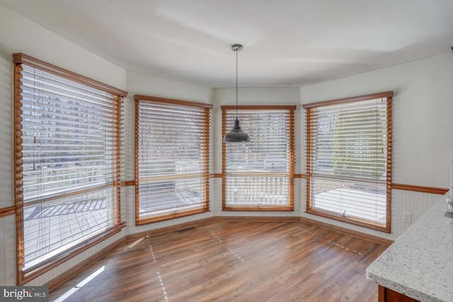 unfurnished dining area with light wood-type flooring and visible vents