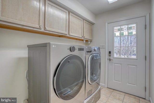 laundry room with washing machine and dryer, cabinet space, and light tile patterned floors