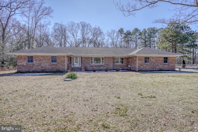 ranch-style house featuring a shingled roof, a front yard, crawl space, and brick siding