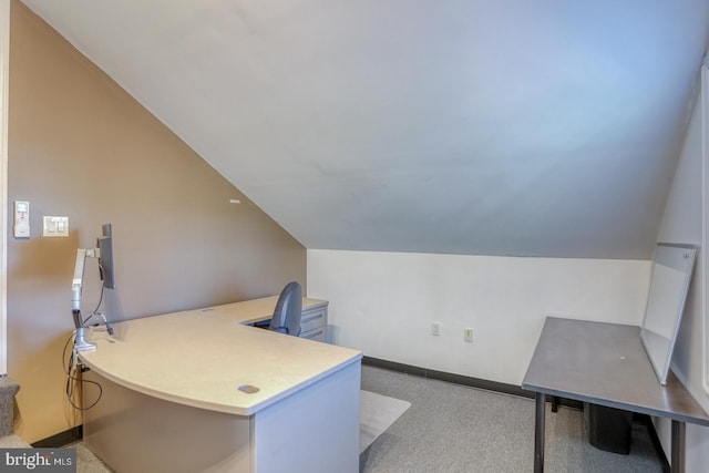 carpeted home office with lofted ceiling and baseboards