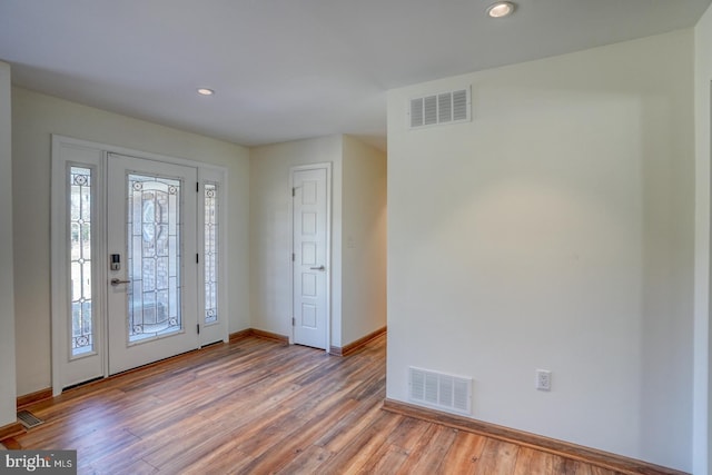 foyer featuring baseboards, visible vents, wood finished floors, and recessed lighting