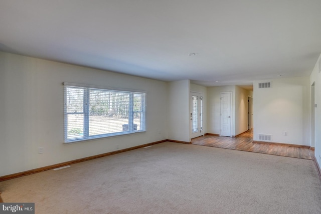 unfurnished room with baseboards, visible vents, and carpet flooring